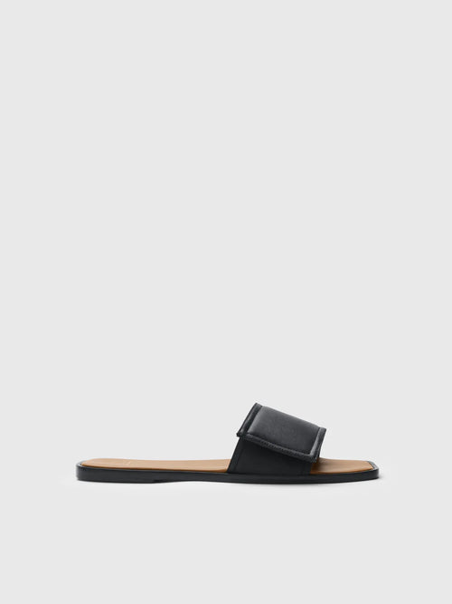 Black sandal with a strap on a light gray background