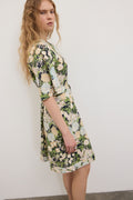 Woman wearing a floral dress against a plain background