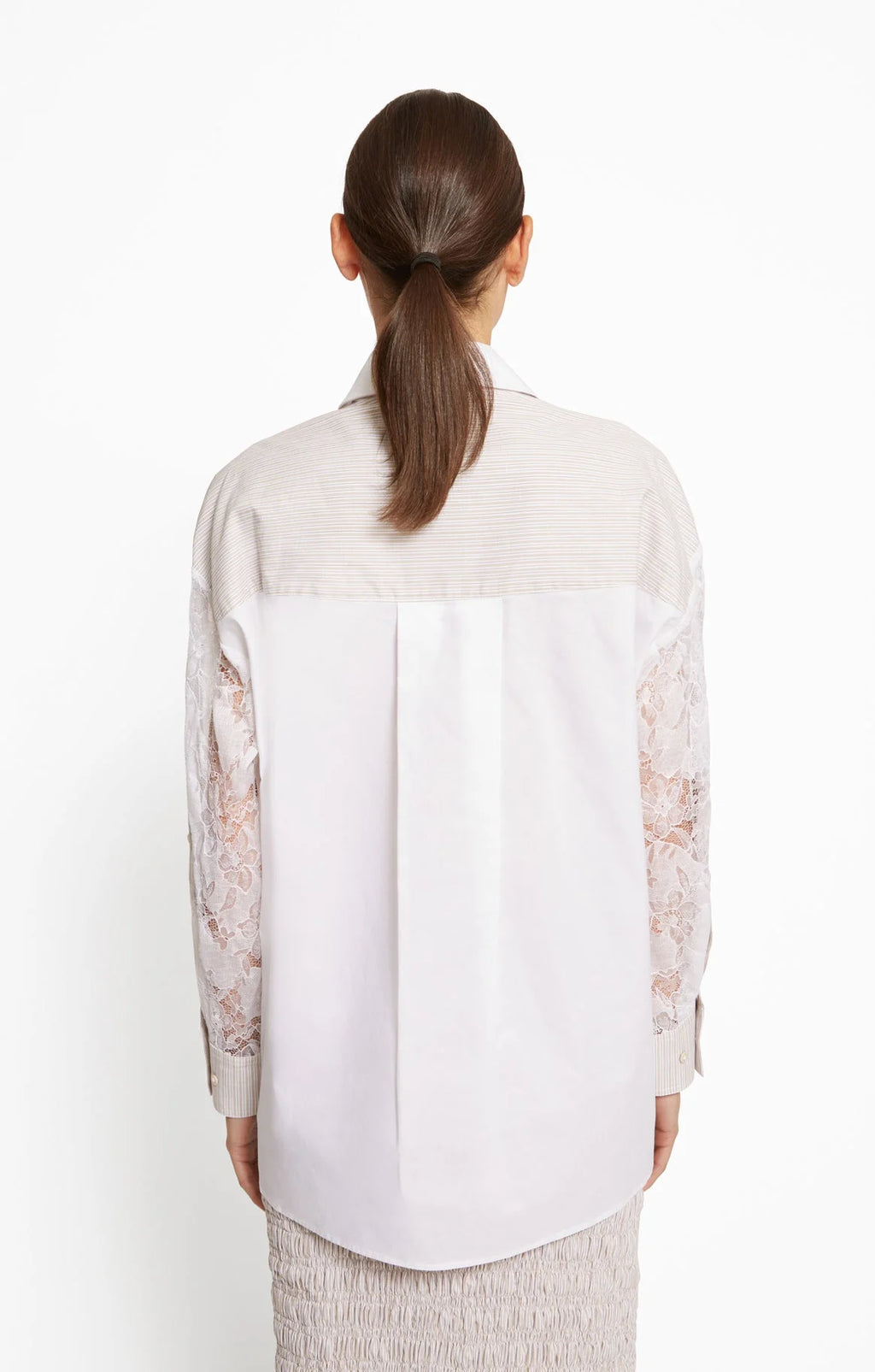 Woman wearing a white blouse with lace sleeves on a white background