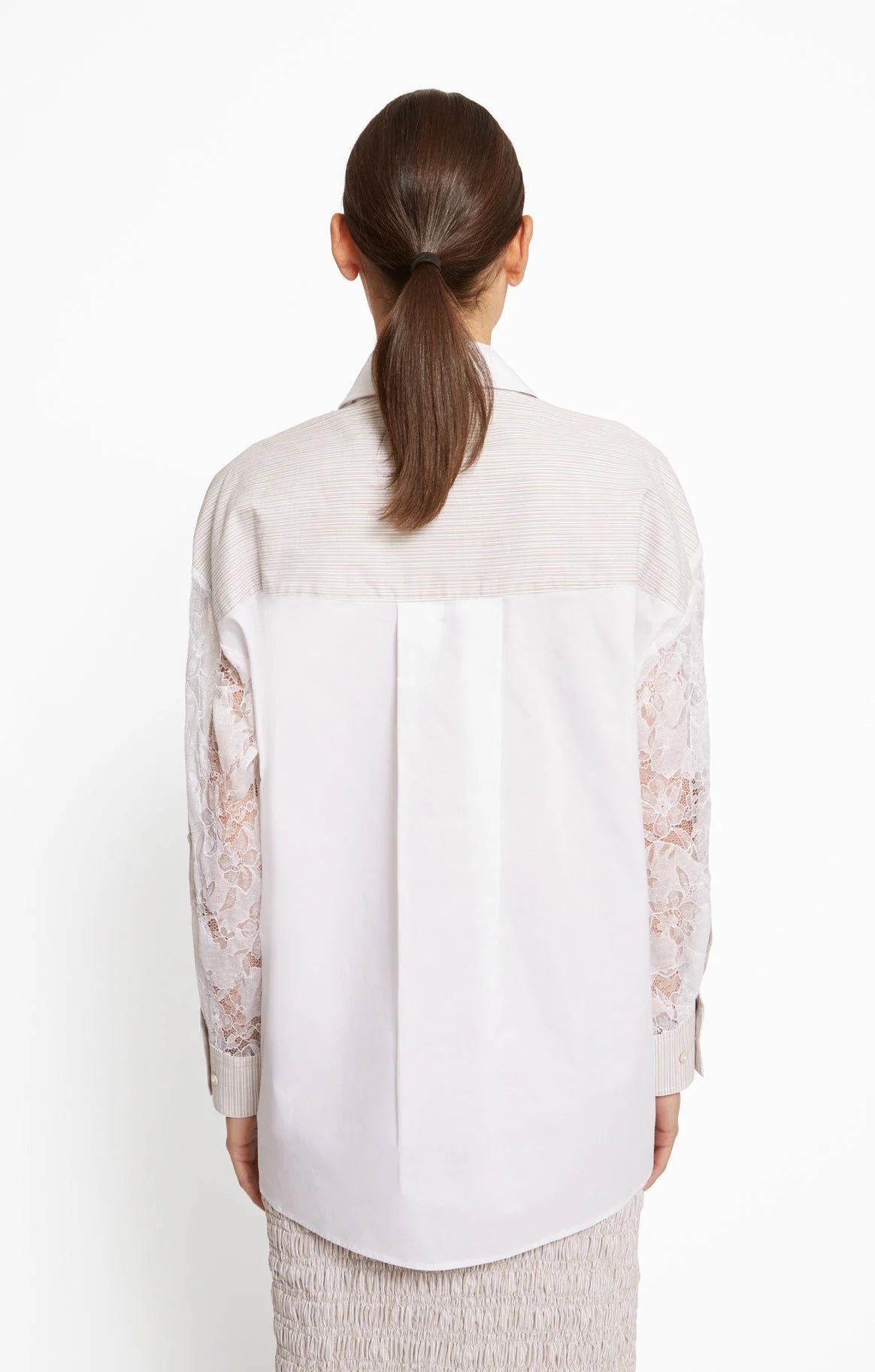 Woman wearing a white blouse with lace sleeves on a white background