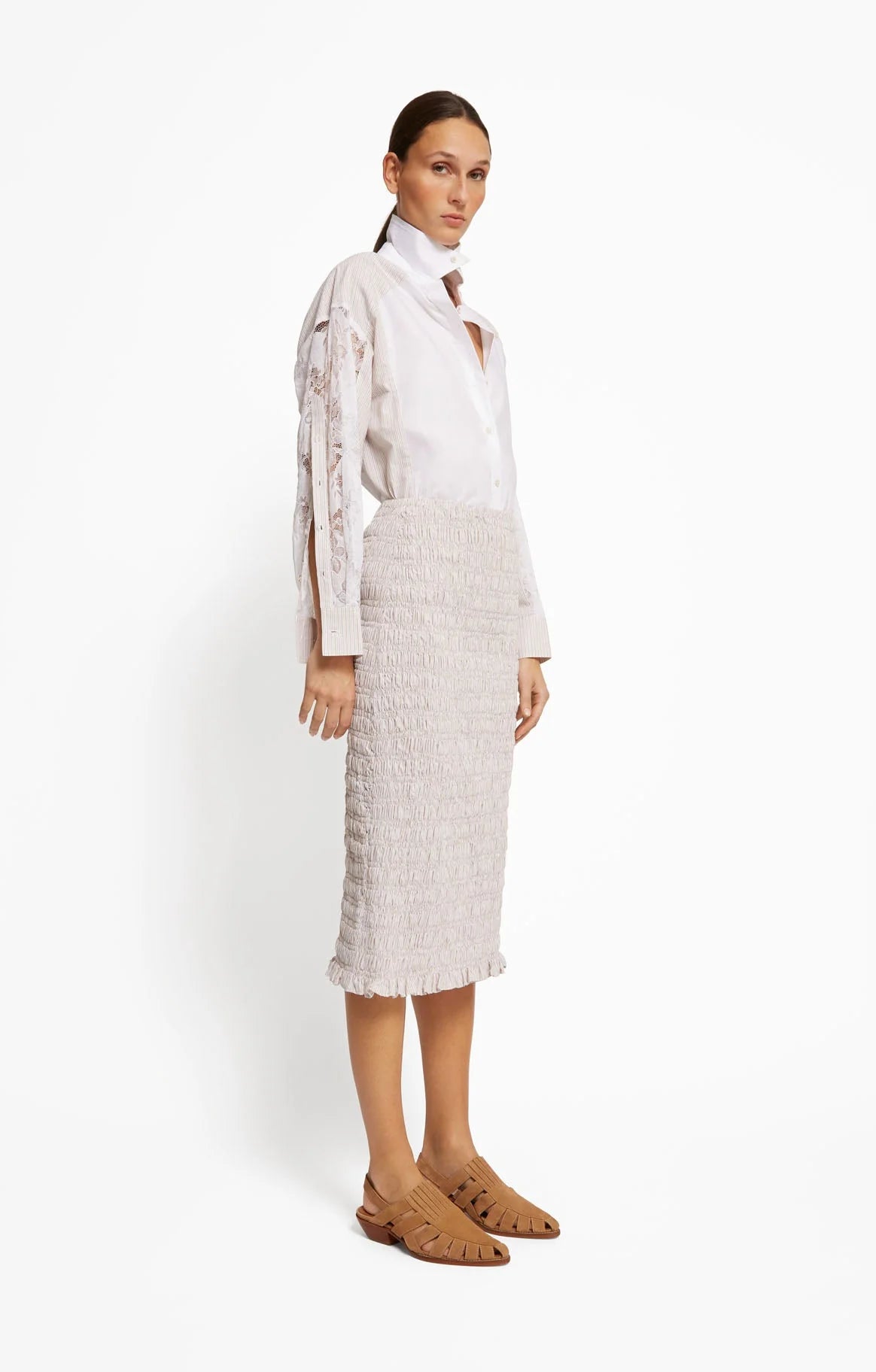 Woman wearing a white blouse and beige skirt on a white background