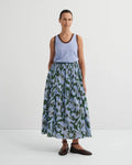 Woman wearing green/light blue Poet skirt by Kowtow with a light blue tank on a white background.