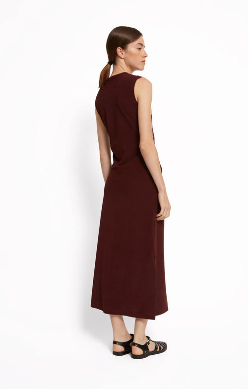 Woman wearing a cherry red sleeveless dress by Roseanna